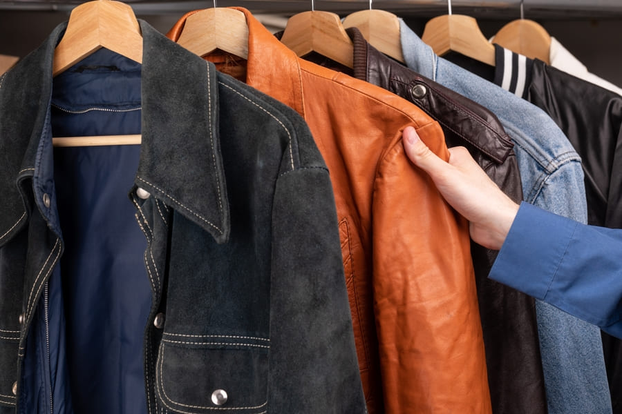 a row of leather jackets hanging on a rack